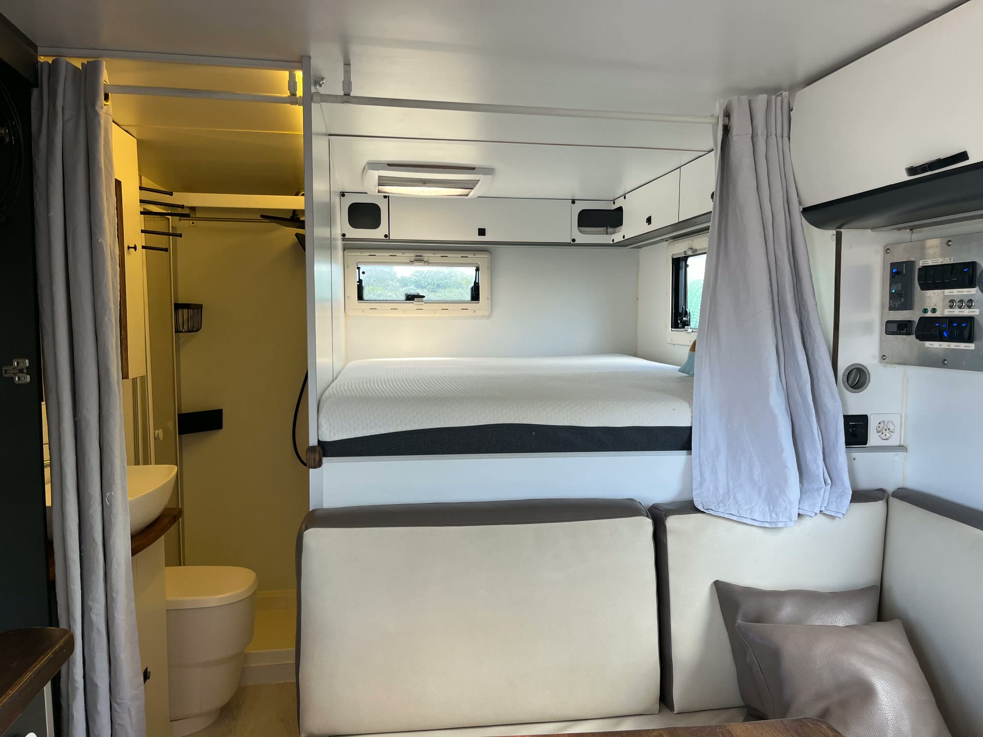 Innenraum mit Sitzgruppe, Bett und offenem Badezimmer