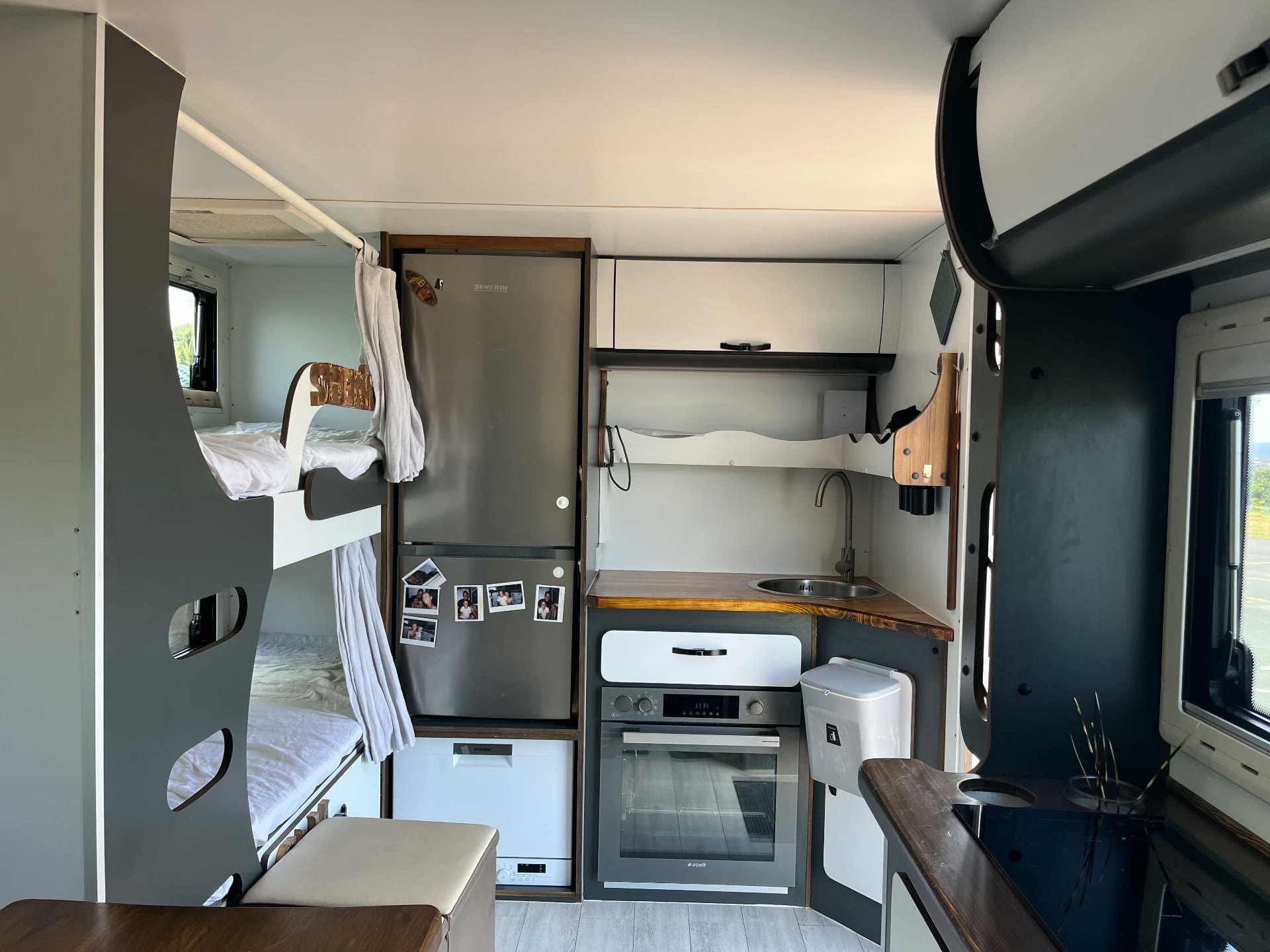 Blick in den Innenraum mit Küche, Kühlschrank und Stockbett